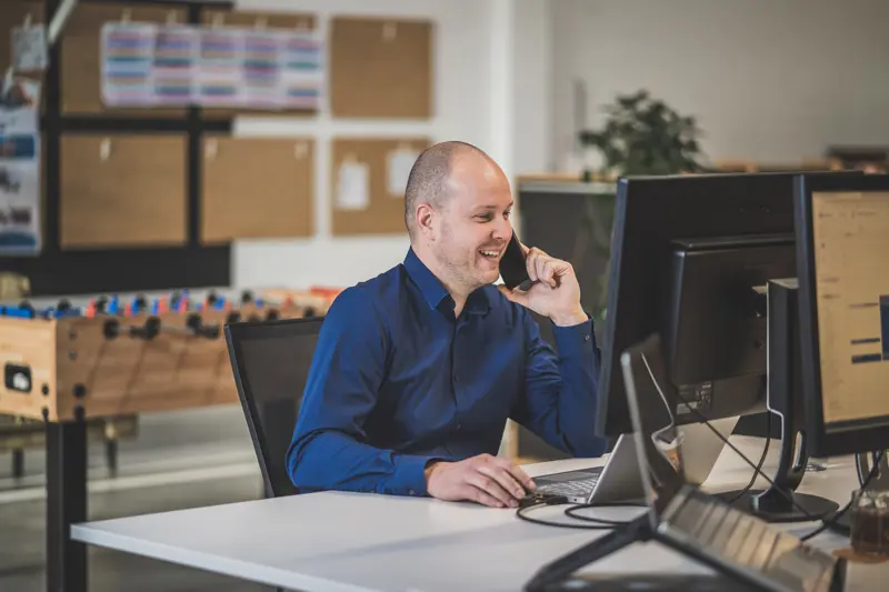 foto van bellende medewerker Dave achter zijn bureau