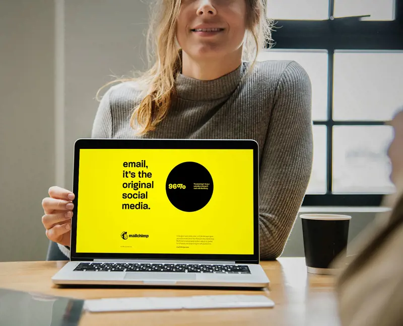 afbeelding van vrouw met laptop waar "email, it's the original social media." op staat op een gele achtergrond