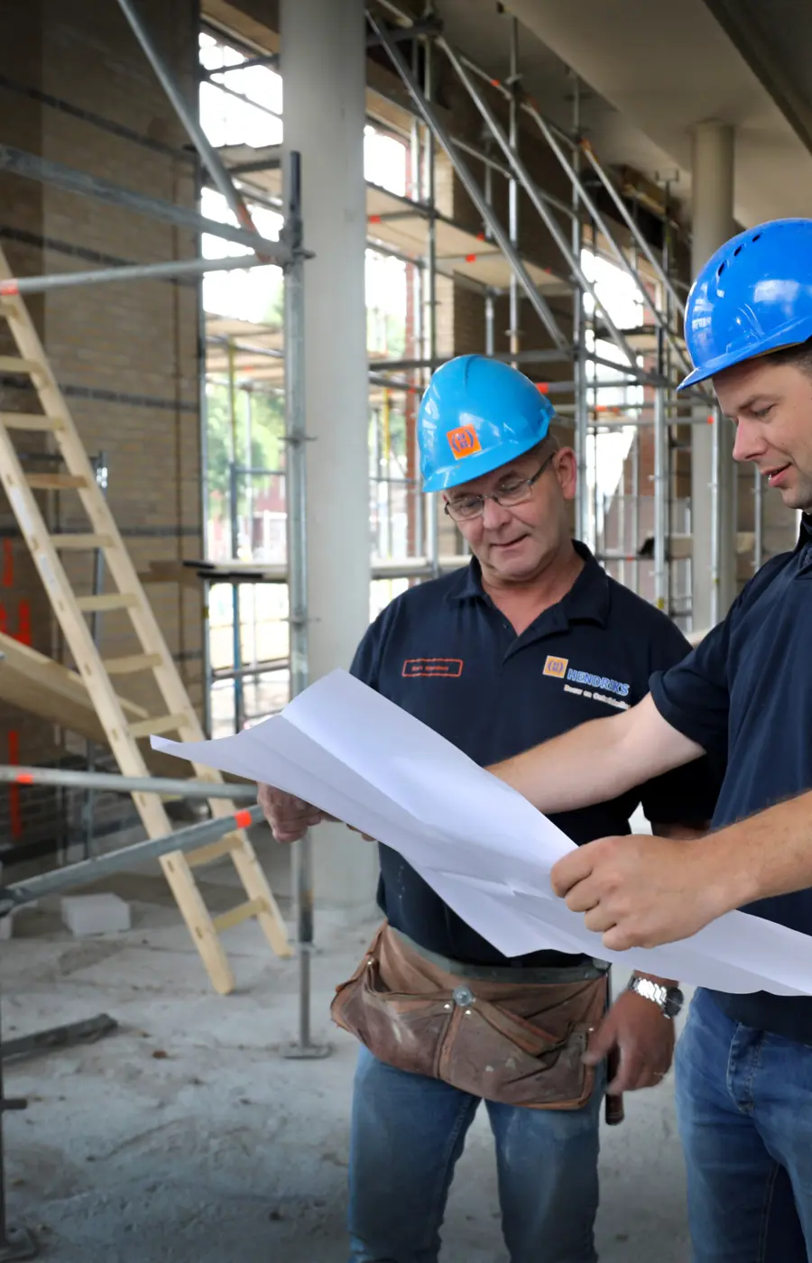 medewerkers Hendriks Bouw en Ontwikkeling kijken bij een project naar de plattegrond