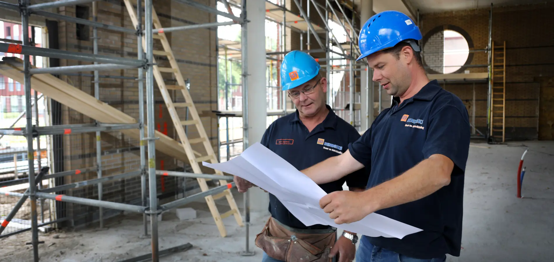 medewerkers Hendriks Bouw en Ontwikkeling kijken bij een project naar de plattegrond