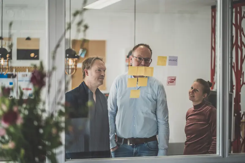 Tijs, Jeroen en Lisa in gesprek in de vergaderruimte